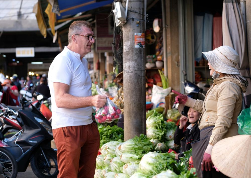 Man talking in the market being immersed in the language